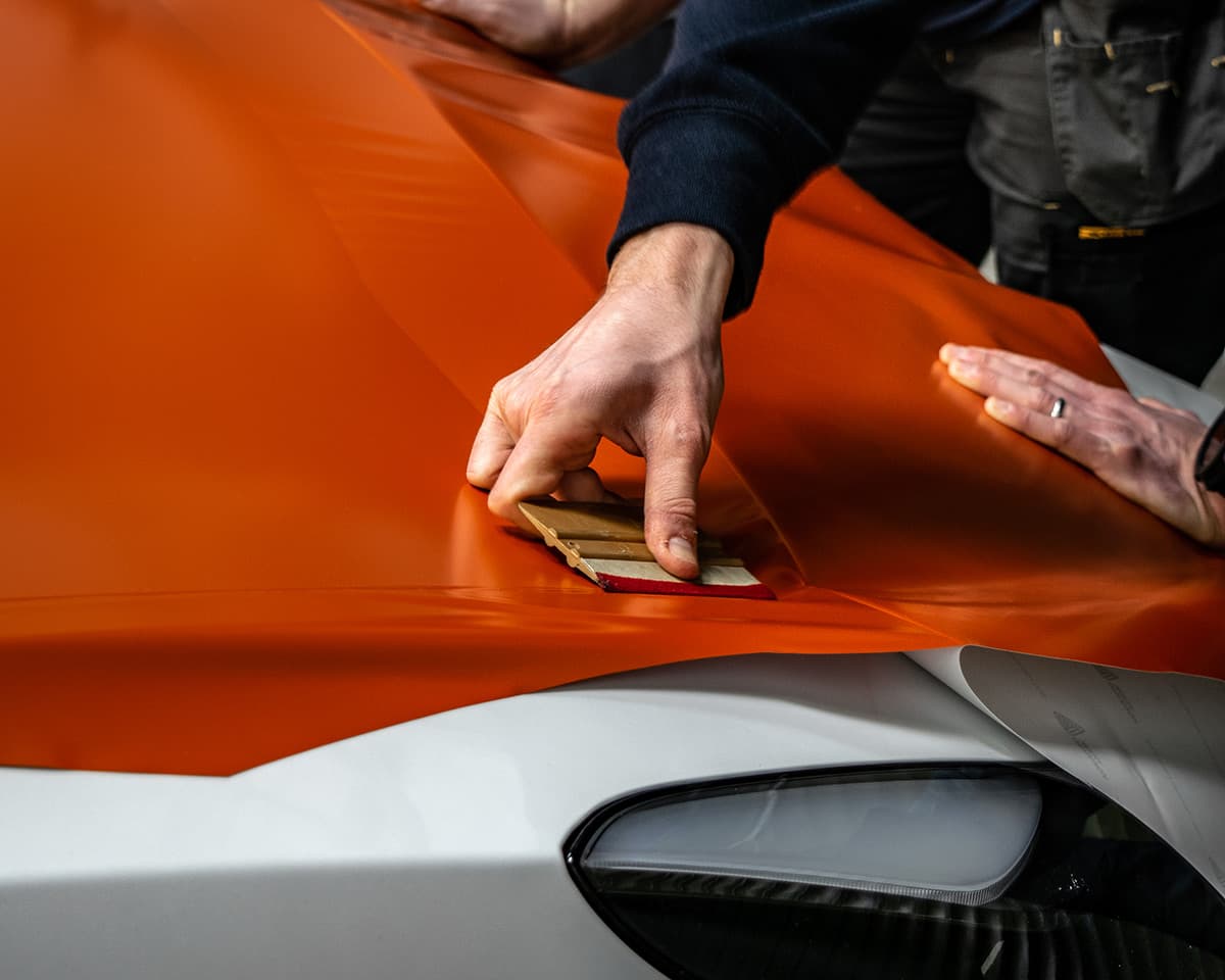 Professional vinyl wrap application process with orange wrap
