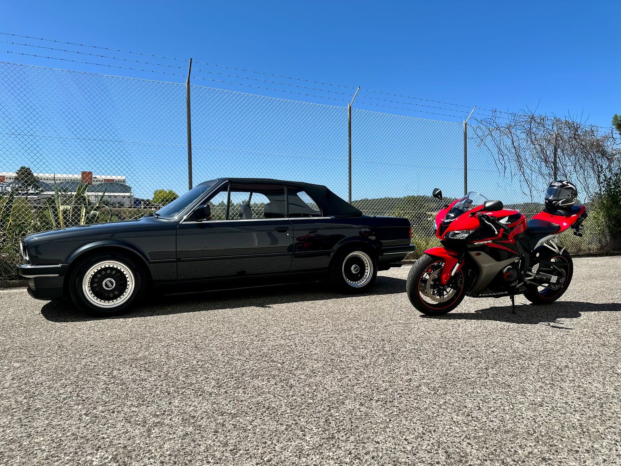 BMW convertible and Honda motorcycle on track