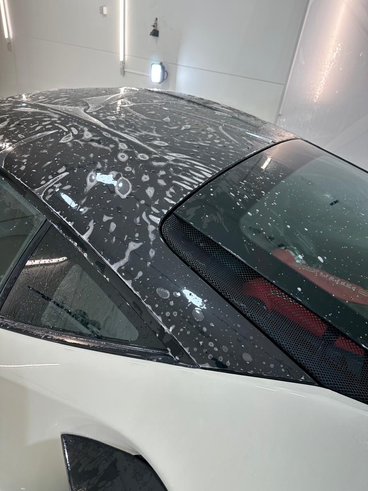 Paint Protection Film installation on car roof showing water droplets during application process